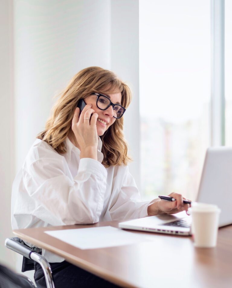 [:de]Eine Frau sitzt an einem Laptop am Tisch[:]